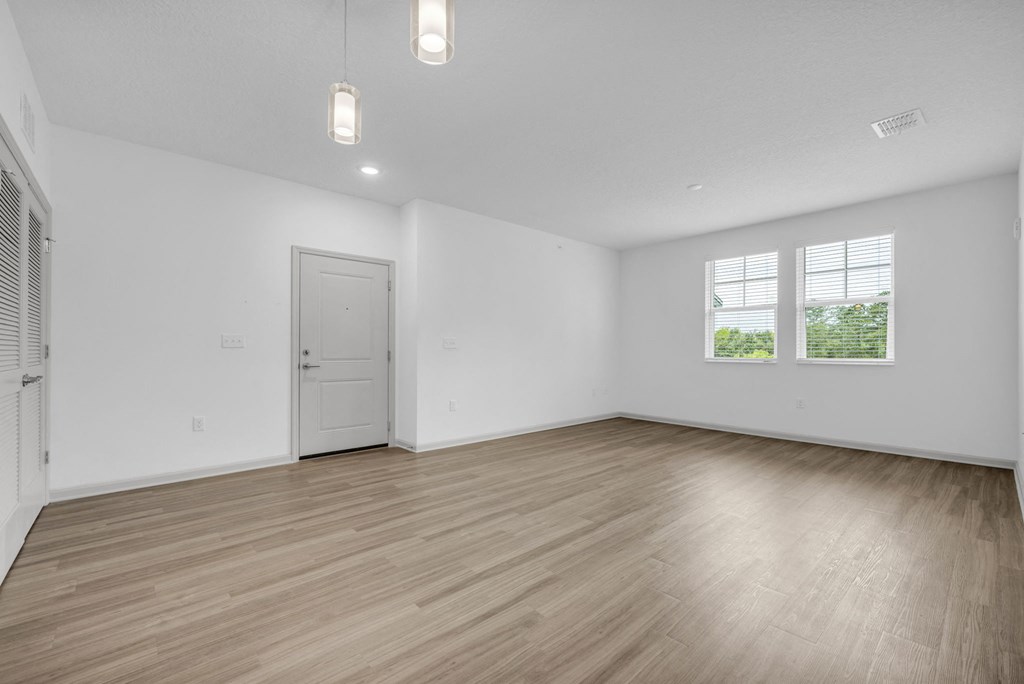 an empty living room with white walls and wood floors