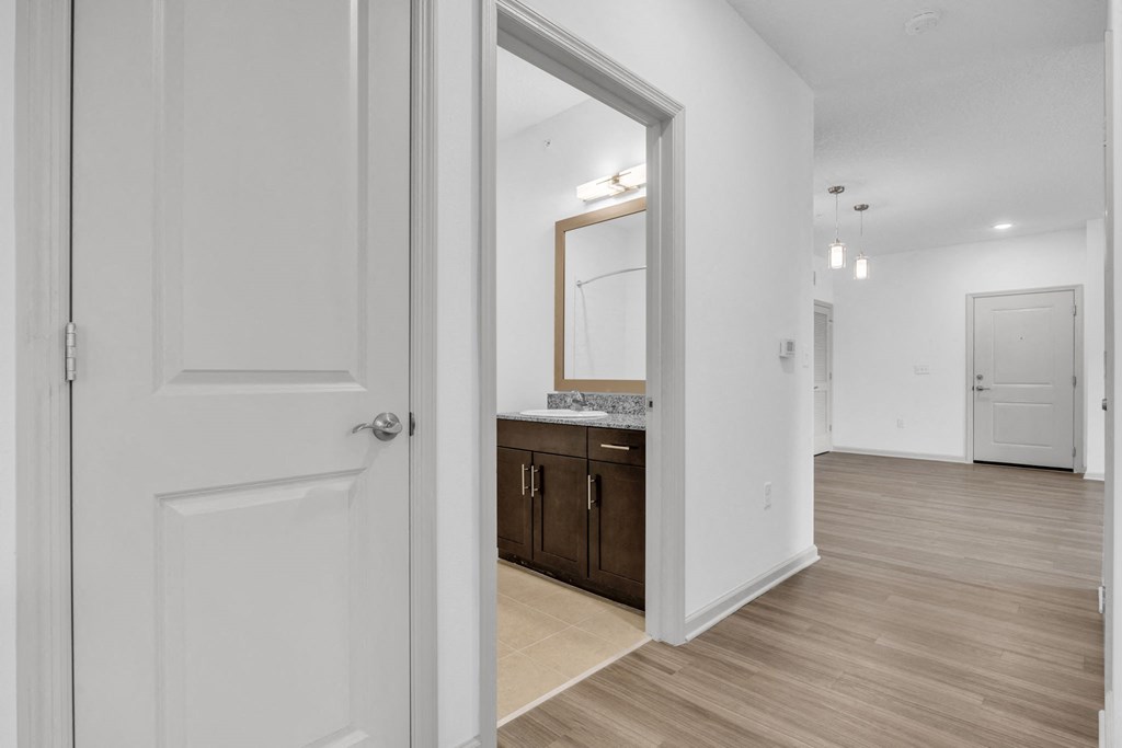 a doorway leading to a bathroom with a sink and a mirror