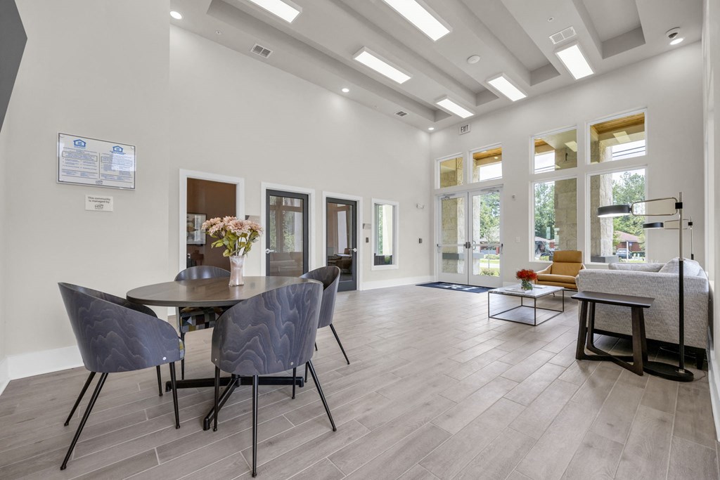 a dining room with a table and chairs and a living room with windows
