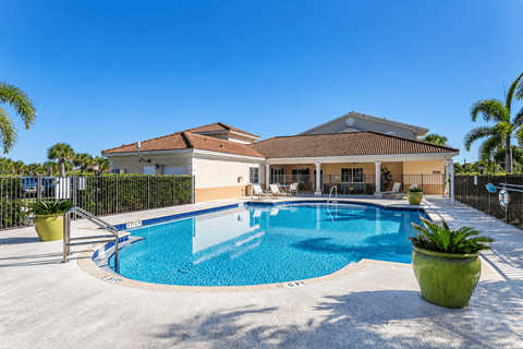 A house with a pool in front of it.