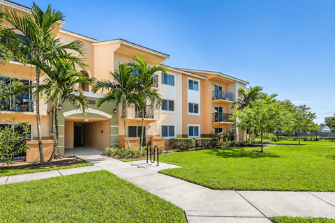 A building with a green lawn in front.