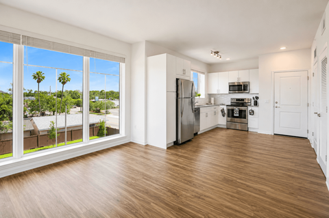 A kitchen with white cabinets and a refrigerator.