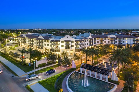 a large fountain sits in front of a large building