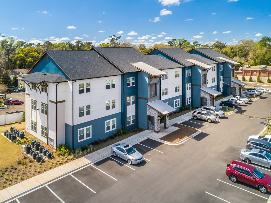 an aerial view of a large apartment complex with cars parked in the parking lot