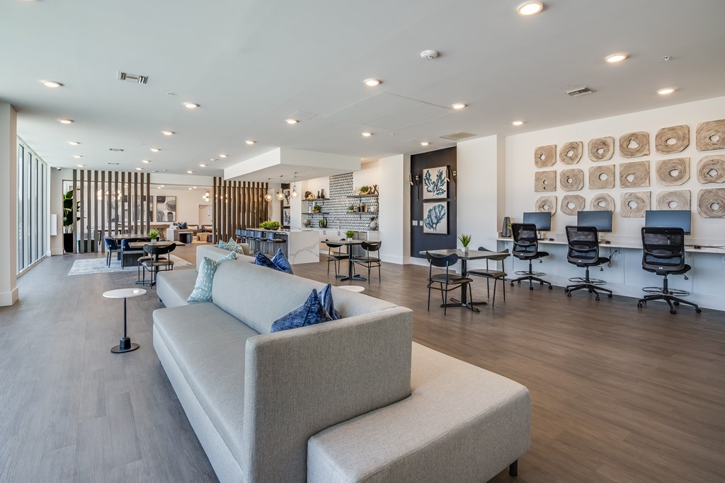 A modern living room with a white sofa and a wooden floor.