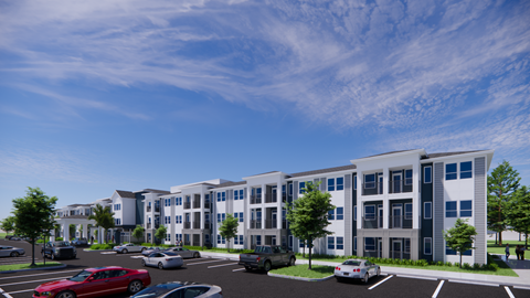 A modern apartment complex with a parking lot in front.