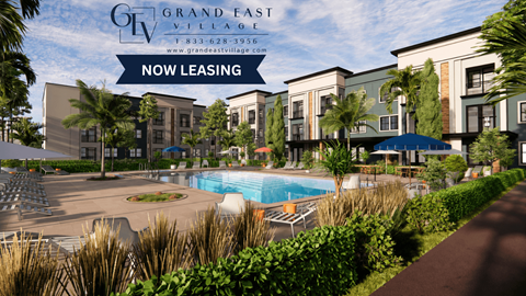 A pool surrounded by chairs and plants is in front of a building that says Grand East Village.