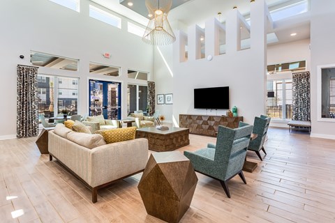 A living room with a sofa, chairs, and a television.