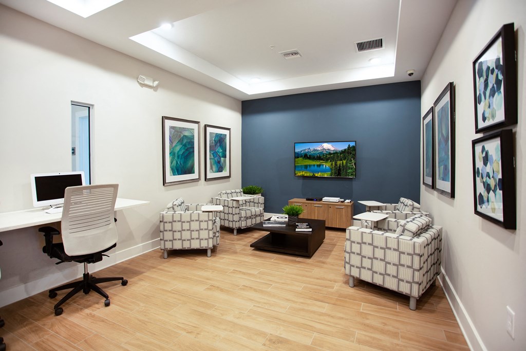 an office with a blue accent wall and wood flooring