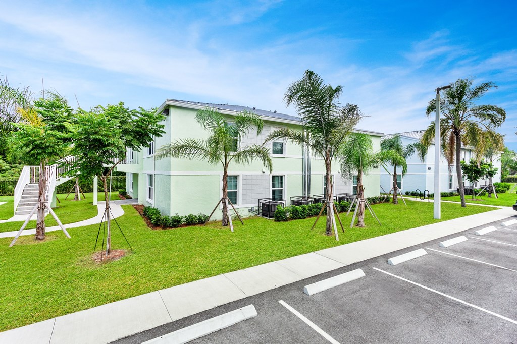 a large white building with palm trees in front of it