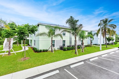 a large white building with palm trees in front of it