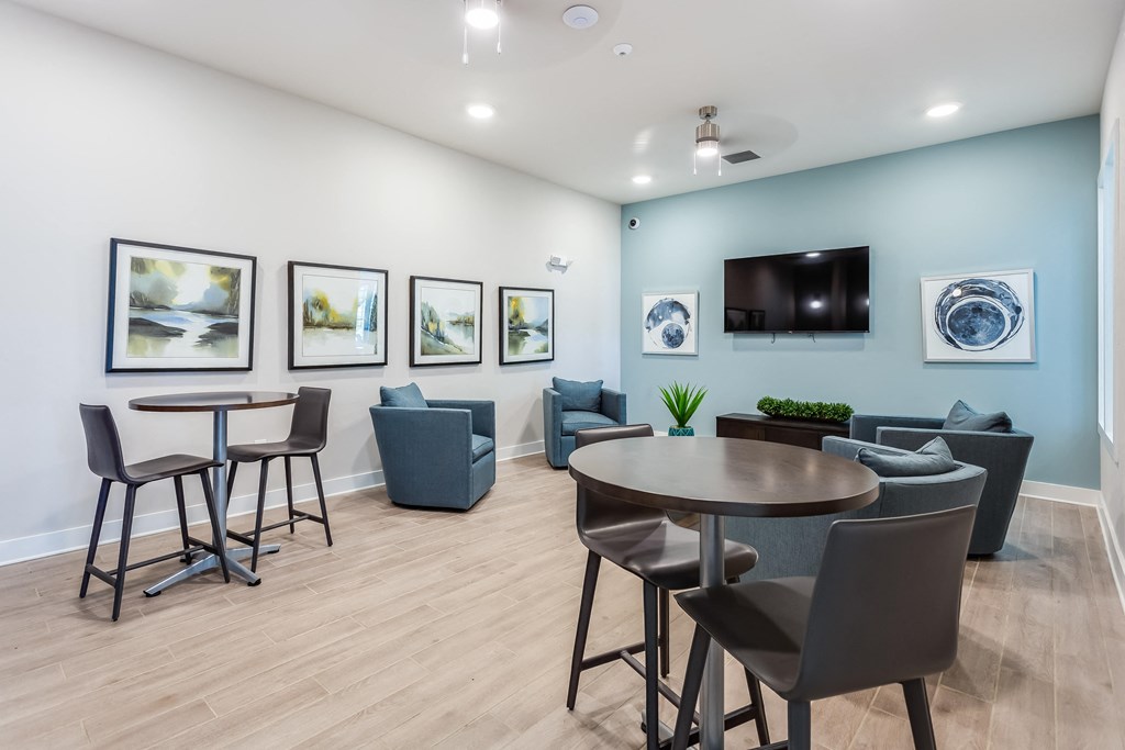 a room with a table and chairs and a flat screen tv on the wall