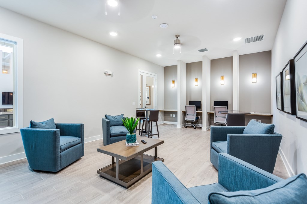 a living room with blue couches and chairs and a coffee table with a plant on it