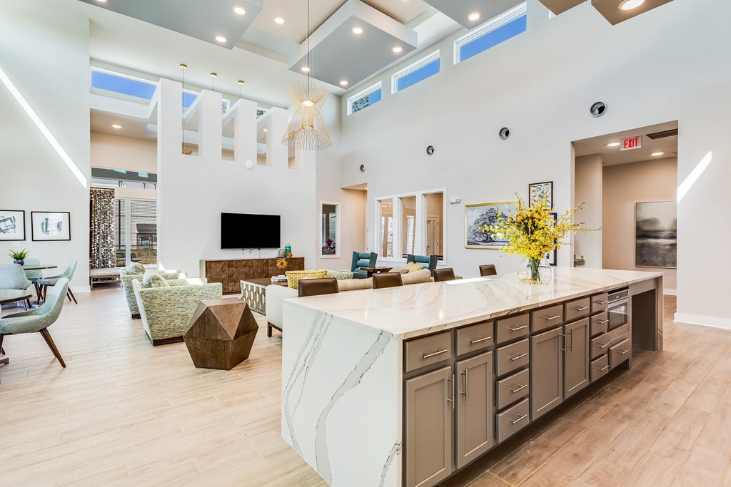 a kitchen with a large center island next to a living room with a couch and a fireplace