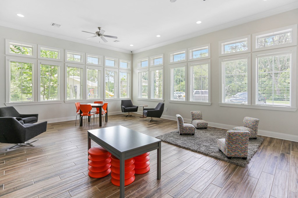 a living room with a table and chairs and a large group of windows