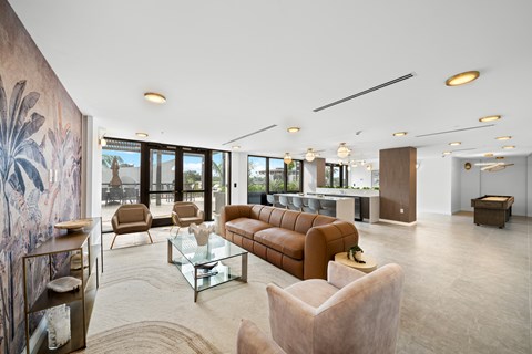 A living room with a brown sofa and a glass coffee table.