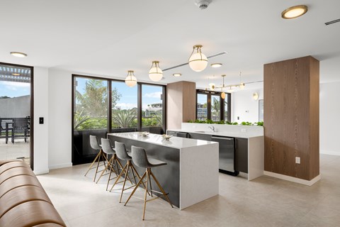 A modern kitchen with a long table and chairs.