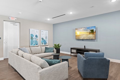 A living room with a couch, chair, and a painting on the wall.