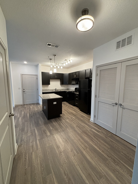 A kitchen with a wooden floor and white walls.