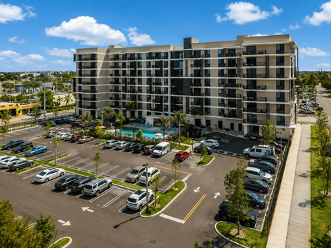 A parking lot in front of a large building.