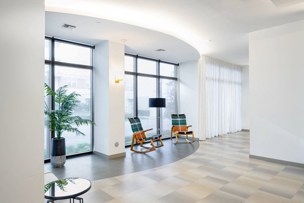 a view of the lobby with two chairs on the left and a lamp on the right