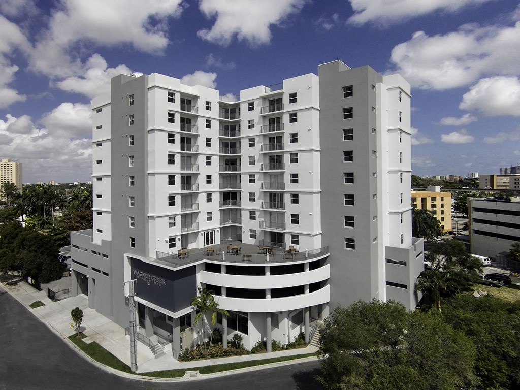an aerial view of the hotel with a blue sky and white clouds in the background