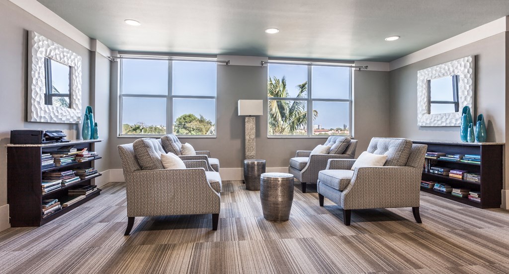 a waiting room with couches chairs and a bookshelf