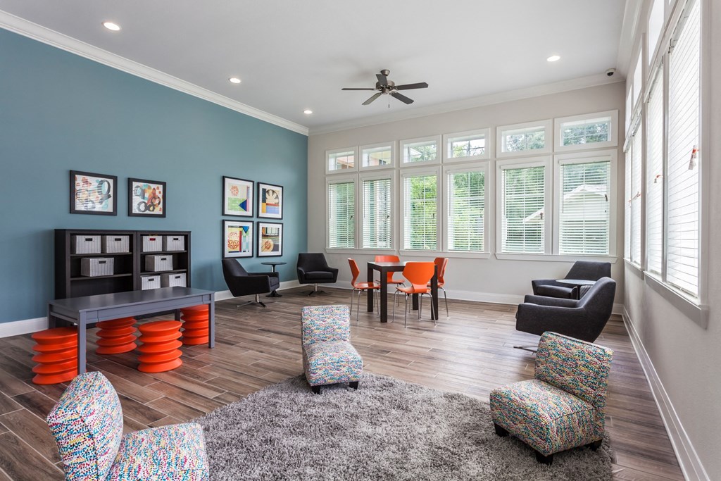 a living room with a table and chairs and a ceiling fan
