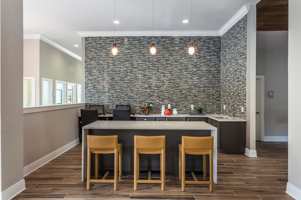 a kitchen with a large island with four chairs in front of it