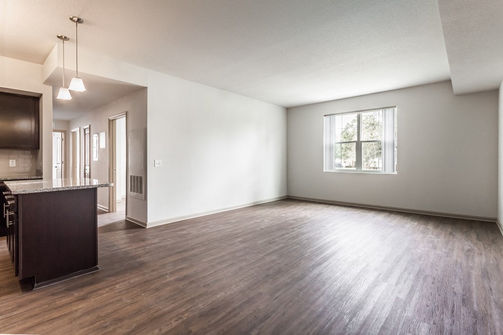 the living room and kitchen of an empty apartment