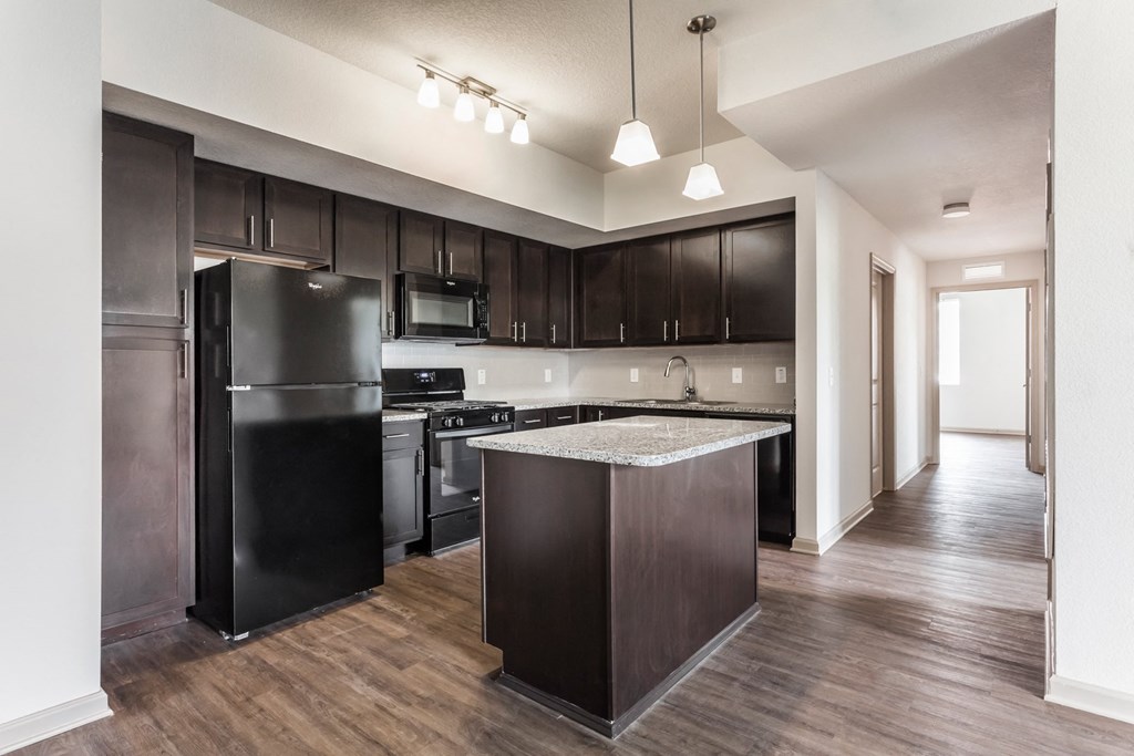 a kitchen with black appliances and dark wood cabinets