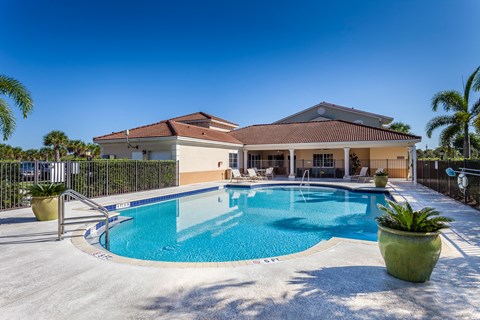 A house with a pool in front of it.