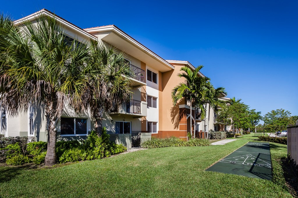 a grassy area with trees and buildings in the background