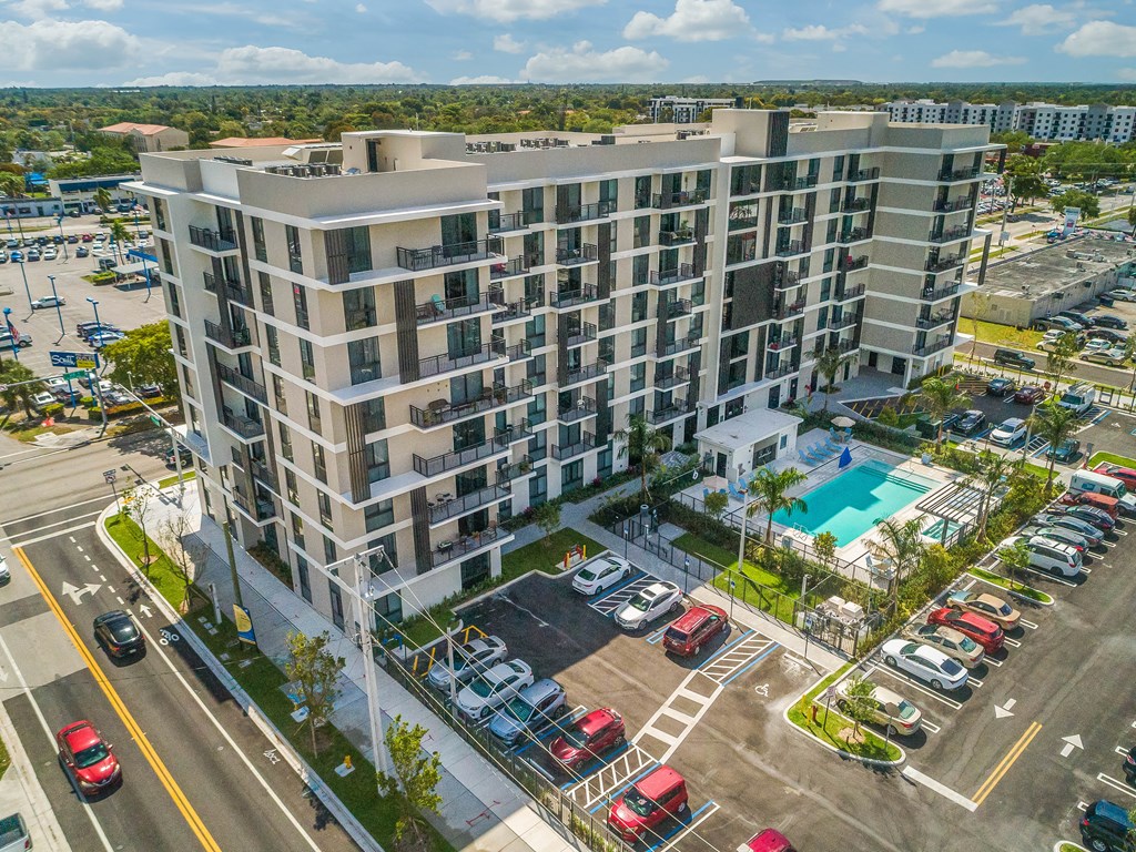 A large apartment building with a pool in the front yard.