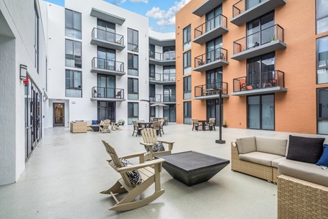 A patio area with furniture and a building in the background.