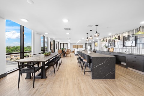A modern kitchen and dining area with a long table and chairs.