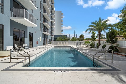 A swimming pool in front of a building with the number 5 on it.