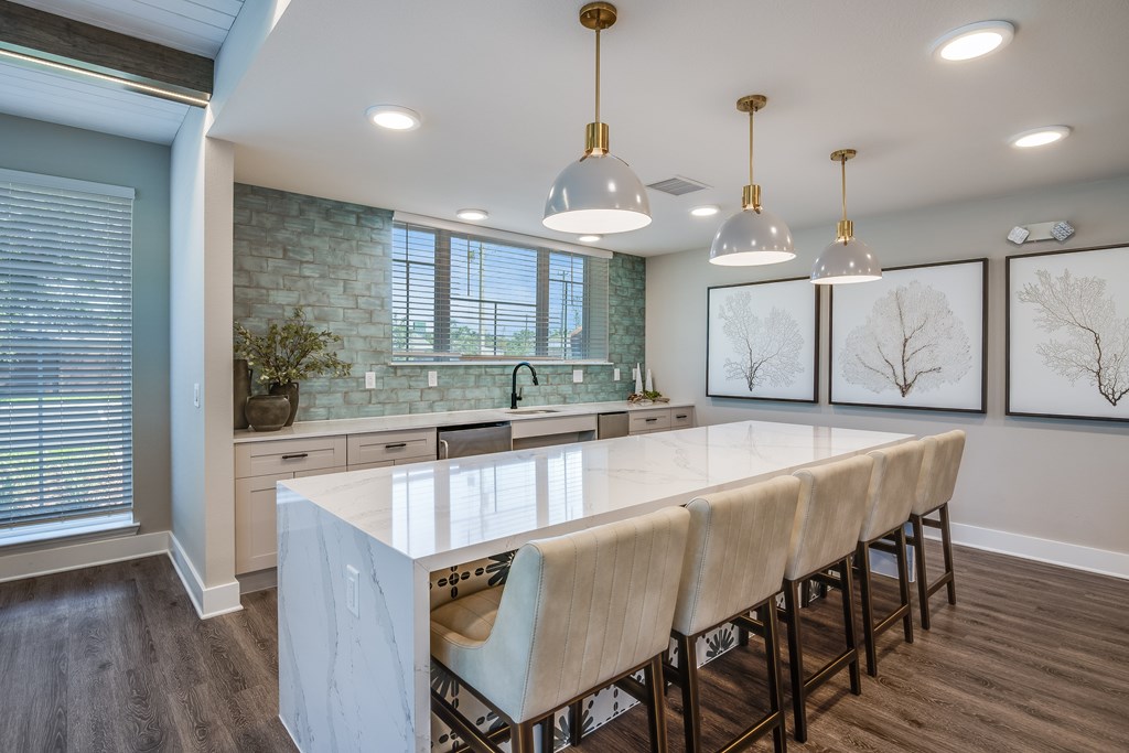 A kitchen with a long table and chairs.