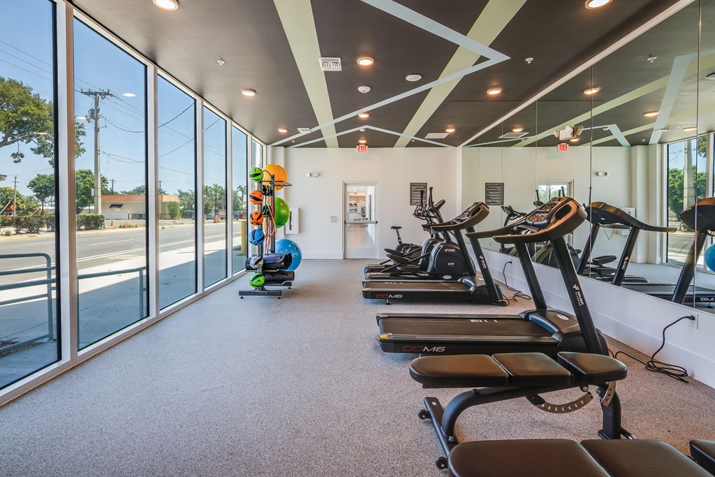 A gym with treadmills, exercise bikes, and a rowing machine.