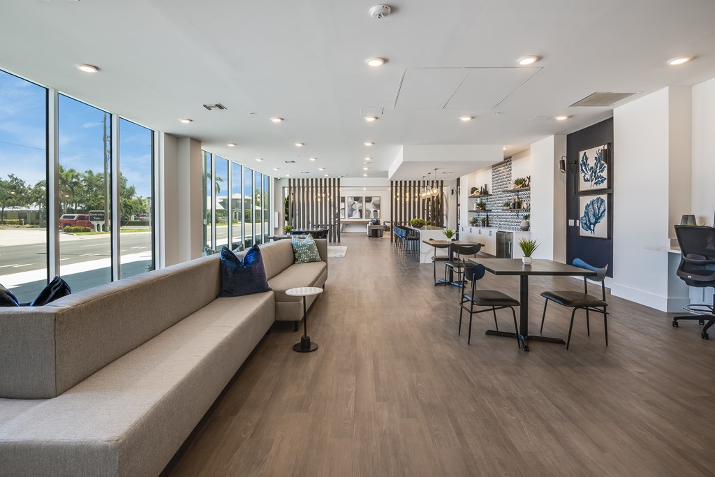 A spacious room with a long couch and a table with chairs.