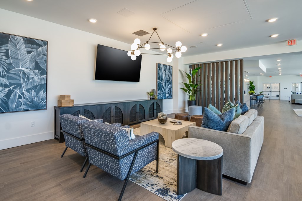 A modern living room with a grey sofa, a blue armchair, and a wooden coffee table.