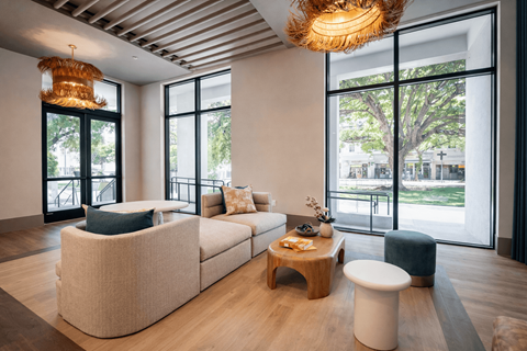 A modern living room with a large window and a wooden coffee table.