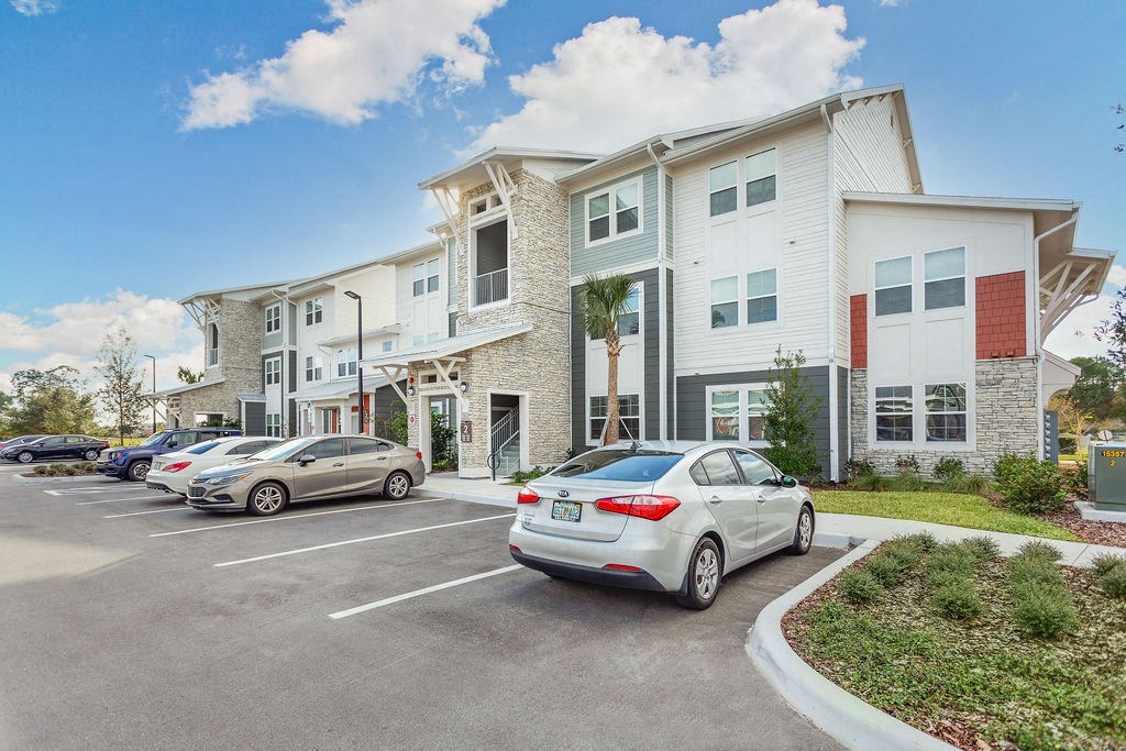 a parking lot with cars in front of a building