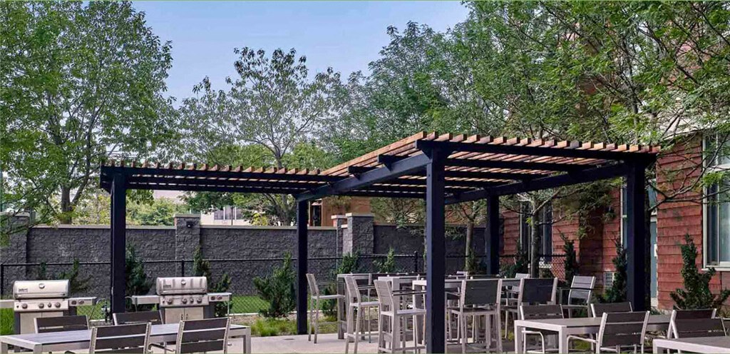 a patio with tables and chairs and a pergola at Shearwood Station, New York