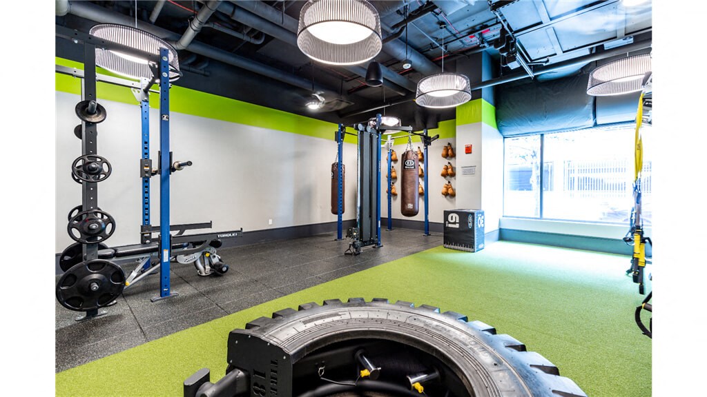 a large tire in a gym with green flooring and a white wall with a window  at Shearwood Station, New Rochelle, New York