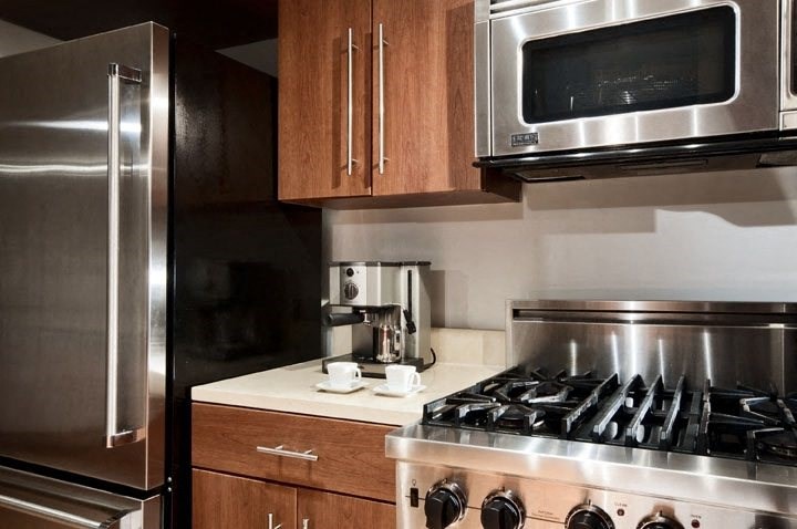 a kitchen with a stove top oven next to a refrigerator a kitchen with a stove top oven next to a refrigerator at The Sheffield Englewood, Englewood, NJ