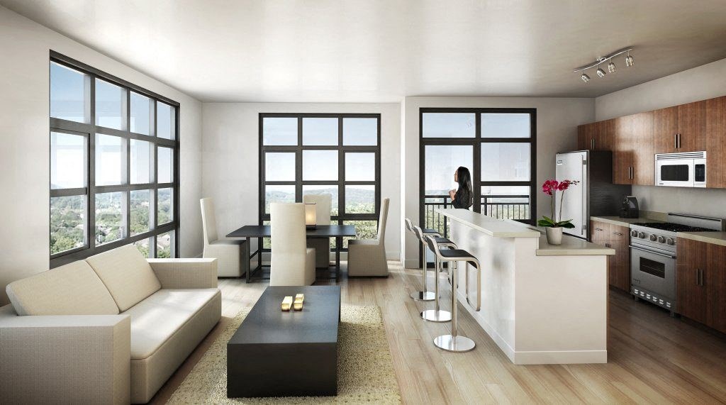 a woman standing in a living room next to a kitchen  at The Sheffield Englewood, Englewood, New Jersey