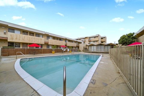A swimming pool in a courtyard surrounded by buildings.