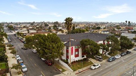 A street view of a residential area with cars parked on the side of the road.