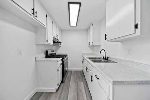 A kitchen with white cabinets and a black stove top oven.